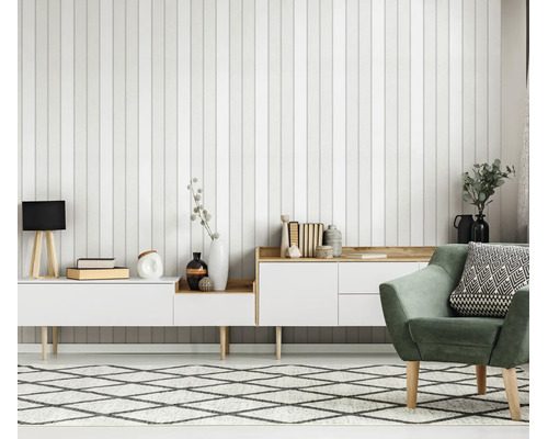 Woonkamer met verticaal gestreept behang, wit dressoir en een groene fauteuil in een moderne Scandinavische stijl.