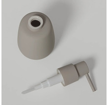 Gedemonteerde zeepdispenser in beige, bestaande uit een bolvormig reservoir en een pompkop.