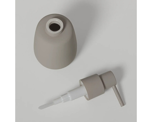 Gedemonteerde zeepdispenser in beige, bestaande uit een bolvormig reservoir en een pompkop.