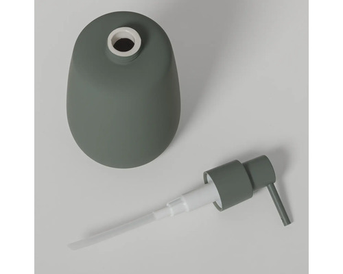 Gedemonteerde zeepdispenser van groen keramiek met een pompje.