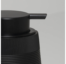 Detailweergave van een zwarte zeepdispenser met een geribbelde behuizing en een gladde pompkop.