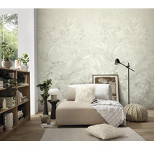Woonkamer met modern vliesbehang met floraal plantmotief op de achtergrond, lichte inrichting met gezellige bank, houten rek en decoratie.
