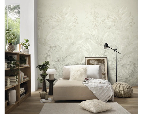 Woonkamer met modern vliesbehang met floraal plantmotief op de achtergrond, lichte inrichting met gezellige bank, houten rek en decoratie.