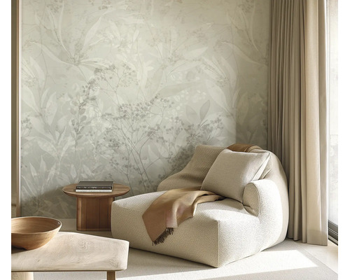 Woonkamer met vliesbehang met floraal bladerpatroon, comfortabele fauteuil, bijzettafel en gordijnen voor een rustige sfeer.