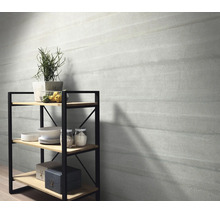 Muur met tegels in steenlook en een metalen rek met houten planken en decoratieve objecten in een woonruimte.