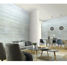 Woonkamer met vliesbehang in houtlook met horizontale nerf, modern interieur met grijze fauteuils, houten tafel en hanglampen.