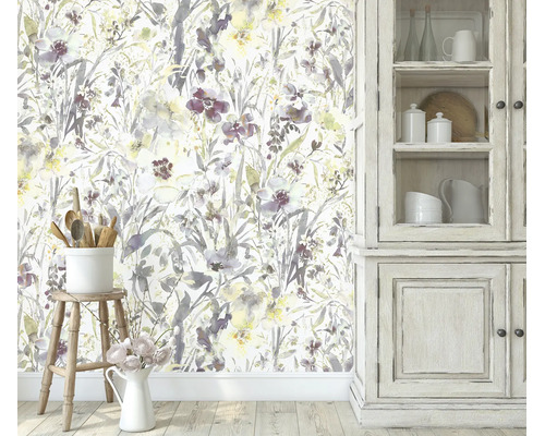 Woonkamermuur met bloemenbehang met aquarelbloempatroon naast een rustieke houten kast en kruk met keukengerei.
