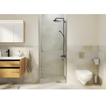 Moderne badkamer met glazen douche, houten wastafelmeubel, hangend toilet en donkere douchekraan in een licht betegelde ruimte.