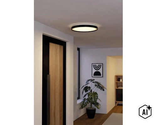 Platte, ronde LED-plafondlamp met zwarte rand, brandend in een modern ingerichte gang met houten deur en plant. (Image AI modified or generated)