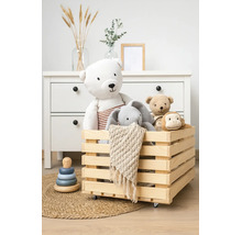 Houten kist op wielen gevuld met knuffels in een georganiseerde kinderkamer met ladekast.