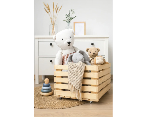 Houten kist op wielen gevuld met knuffels in een georganiseerde kinderkamer met ladekast.