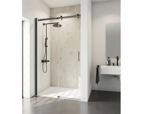 Moderne douchecabine met schuifdeur en zwart beslag, geïnstalleerd in een lichte badkamer met regendouche en wandhangende wastafel.