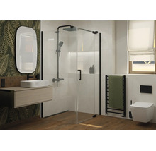 Moderne badkamer met glazen douchecabine, hangende wastafel, ovale spiegel en hangend toilet voor een muur met bladerpatroon.