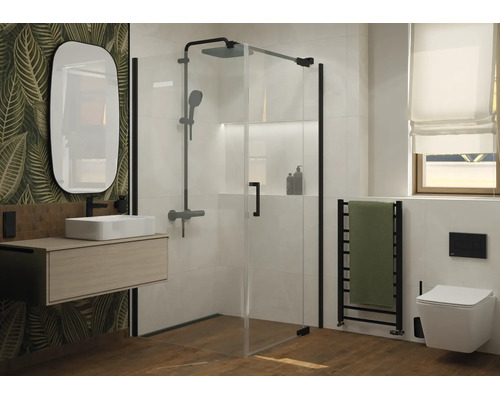 Moderne badkamer met glazen douchecabine, hangende wastafel, ovale spiegel en hangend toilet voor een muur met bladerpatroon.
