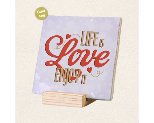 Vierkant decoratief bordje van keramiek met tekst Life is Love Enjoy it en goudfolie afwerking op een houten standaard