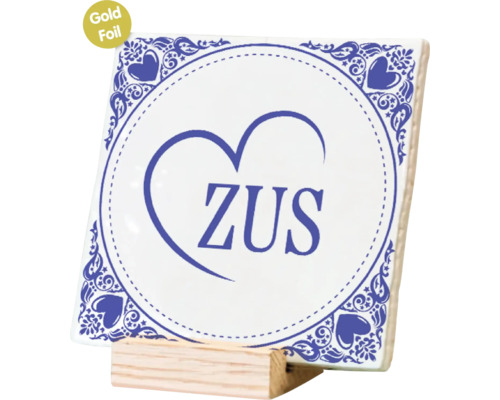 Vierkante tegel met decoratieve opdruk en de tekst ZUS, gepresenteerd op een houten houder.