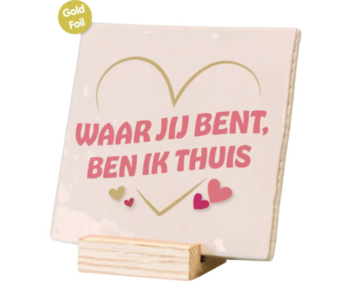 Vierkant decoratief bordje met opdruk Waar jij bent, ben ik thuis en hartjes, met goudfolie afwerking, staand op een houten standaard.