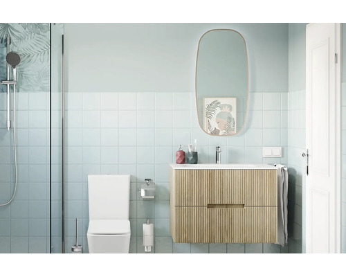 Moderne badkamer met een zwevend wastafelmeubel met ribbelstructuur, een ovale spiegel, een toilet en een douche met glazen wand.