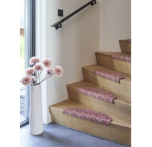 Trapmatten met ornamentaal patroon op een houten trap, gedecoreerd met een hoge vloervaas en kunstbloemen in een modern interieur.