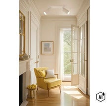 Een lichte gang met plafondspots en een gele fauteuil voor een openslaande deur met glas en een open haard. (Image AI modified or generated)