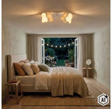Gezellige slaapkamer met moderne plafondlamp met twee golvende lampenkappen, zicht op een verlicht terras in de schemering. (Image AI modified or generated)