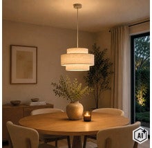 Moderne hanglamp met getrapte stoffen kap boven een ronde eettafel in een sfeervol verlichte woonkamer. (Image AI modified or generated)