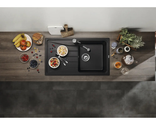Bovenaanzicht van een inbouwspoelbak met afdruipblad in een moderne keuken met werkblad in houtlook en decoratie.