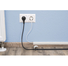 Kabelgoot voor discrete kabelgeleiding op de muur boven de plint met elektrische kabels