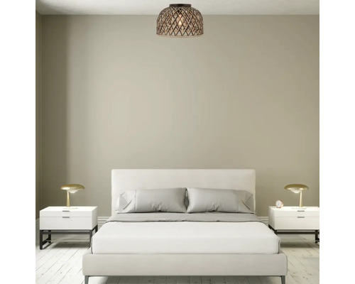 Een moderne slaapkamer met een licht bed, twee nachtkastjes met tafellampen en een decoratieve plafondlamp van vlechtwerk.