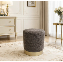 Ronde gestoffeerde poef met textuur en een metalen voet in een klassiek ingerichte woonkamer.