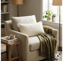 Een comfortabele fauteuil met een gestructureerd kussen met franjes en een zachte deken in een lichte woonkamer met een bijzettafel. (Image AI modified or generated)