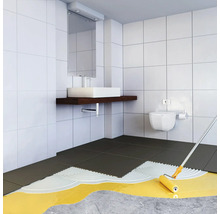 Moderne badkamerrenovatie met betegeling en het aanbrengen van primer met een verfroller op een betonnen vloer.
