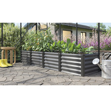 Rechthoekige metalen verhoogde plantenbak in een kas, beplant met tomaten en sla op een bestraat terras in de tuin.