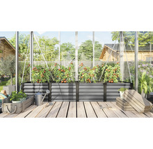 Grote verhoogde plantenbak van metaal in een kas met tomatenplanten op een houten terras