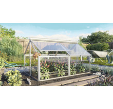 Een kleine glazen kweekbak in de tuin met openslaande deksels voor het buiten kweken van planten.