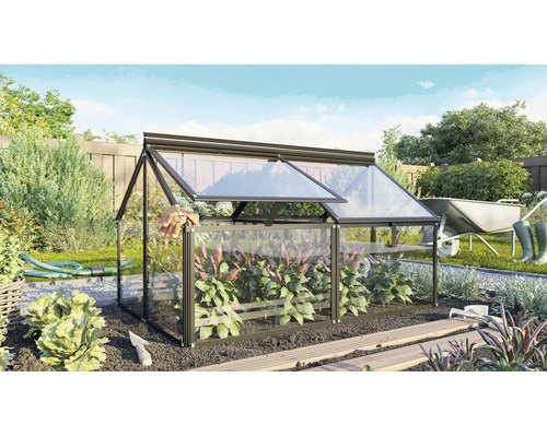 Een kleine kas met metalen frame en glazen panelen in de tuin, met een dakraam dat open kan voor het kweken van planten.