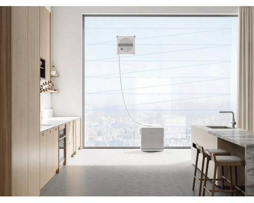 Raamreinigingsrobot aan het werk op een grote ruit in een moderne, lichte keuken.