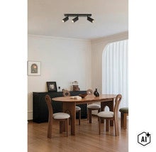 Moderne plafondlamp met drie spots boven een houten eettafel in een lichte, stijlvol ingerichte woonruimte. (Image AI modified or generated)
