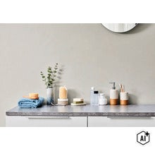 Badkamerinrichting met zeepdispenser tandenborstelbeker en badkameraccessoires op een aanrechtblad in natuursteenlook in een moderne badkamer (Image AI modified or generated)