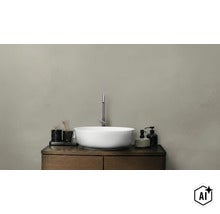 Ronde waskom van keramiek op een donkerhouten wastafelmeubel met kraan en badkameraccessoires in een minimalistische badkamer (Image AI modified or generated)