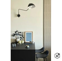 Moderne wandlamp boven een donkere tafel met kunstprint, vaas en koffiekopje in een elegant interieur (Image AI modified or generated)