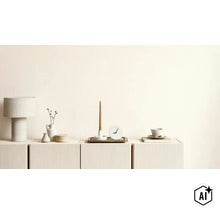 Woonkamer dressoir met tafellamp, kandelaar, kleine klok en decoratie voor een minimalistische inrichting. (Image AI modified or generated)