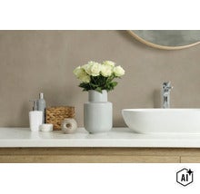Modern badkamerinterieur met witte opzetwastafel, kraan en decoratie zoals een vaas met bloemen op een houten wastafelblad. (Image AI modified or generated)