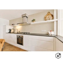 Moderne witte inbouwkeuken met donker aanrechtblad, roestvrijstalen afzuigkap, inbouwoven en open wandplanken in een lichte ruimte. (Image AI modified or generated)