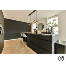 Moderne keuken met kookeiland en barkrukken op visgraat parketvloer (Image AI modified or generated)