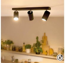 Moderne plafondlamp met drie cilindervormige spots gemonteerd op een rechthoekige rail in een woonruimte (Image AI modified or generated)