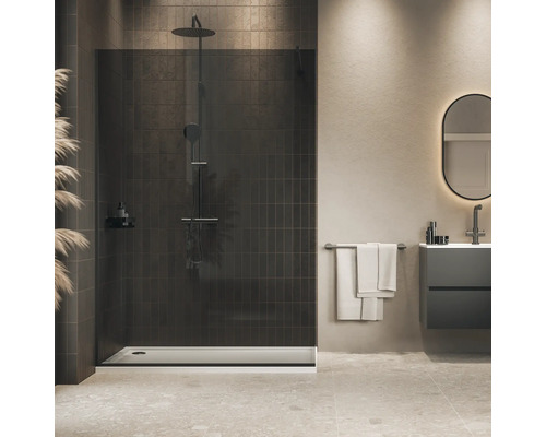 Moderne inloopdouche met donkere glazen douchewand en regendouche in een elegante badkamer met tegels en wastafelmeubel.
