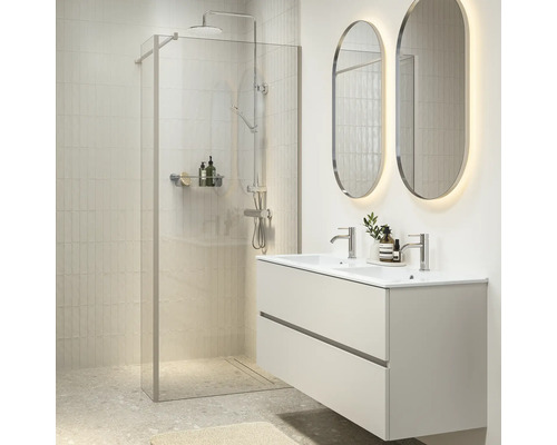 Moderne badkamer met inloopdouche, dubbele wastafel met onderkast en verlichte ovale wandspiegels in een lichte tegelstijl.