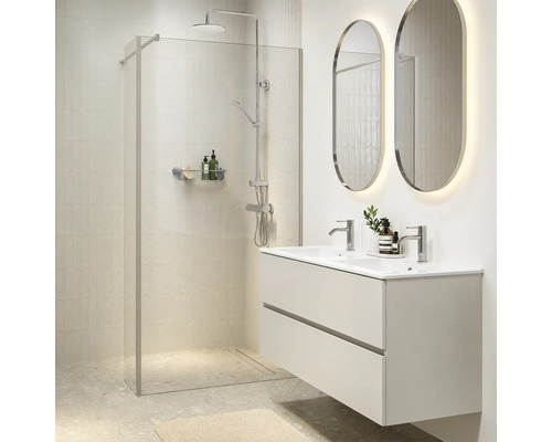 Moderne badkamer met inloopdouche van glas, regendouche, wastafelmeubel met dubbele wastafel en twee ovale verlichte wandspiegels.