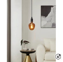 Moderne hanglamp met barnsteenkleurige glazen lichtbron in een elegante woonkamer met bijzettafel en kunstwerk aan de muur (Image AI modified or generated)